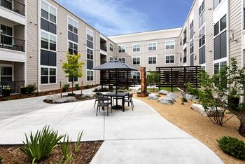 an outdoor patio with tables and chairs in an apartment building  at Watermark on Twenty Mile, Colorado